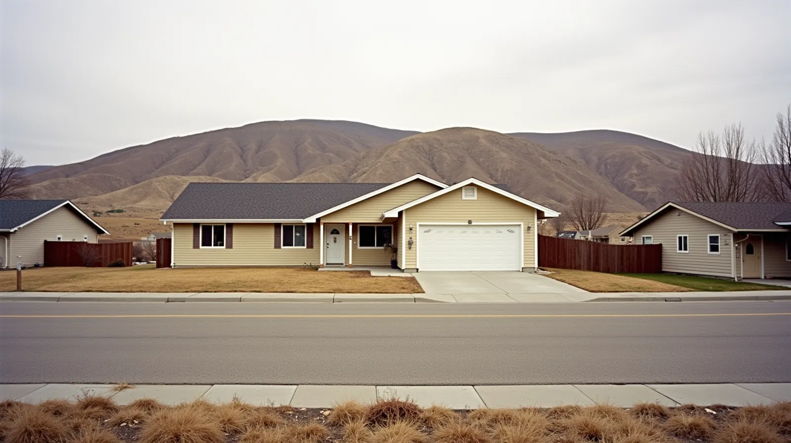 Modest ranch-style home in eastern Washington high desert with brown hills and sagebrush